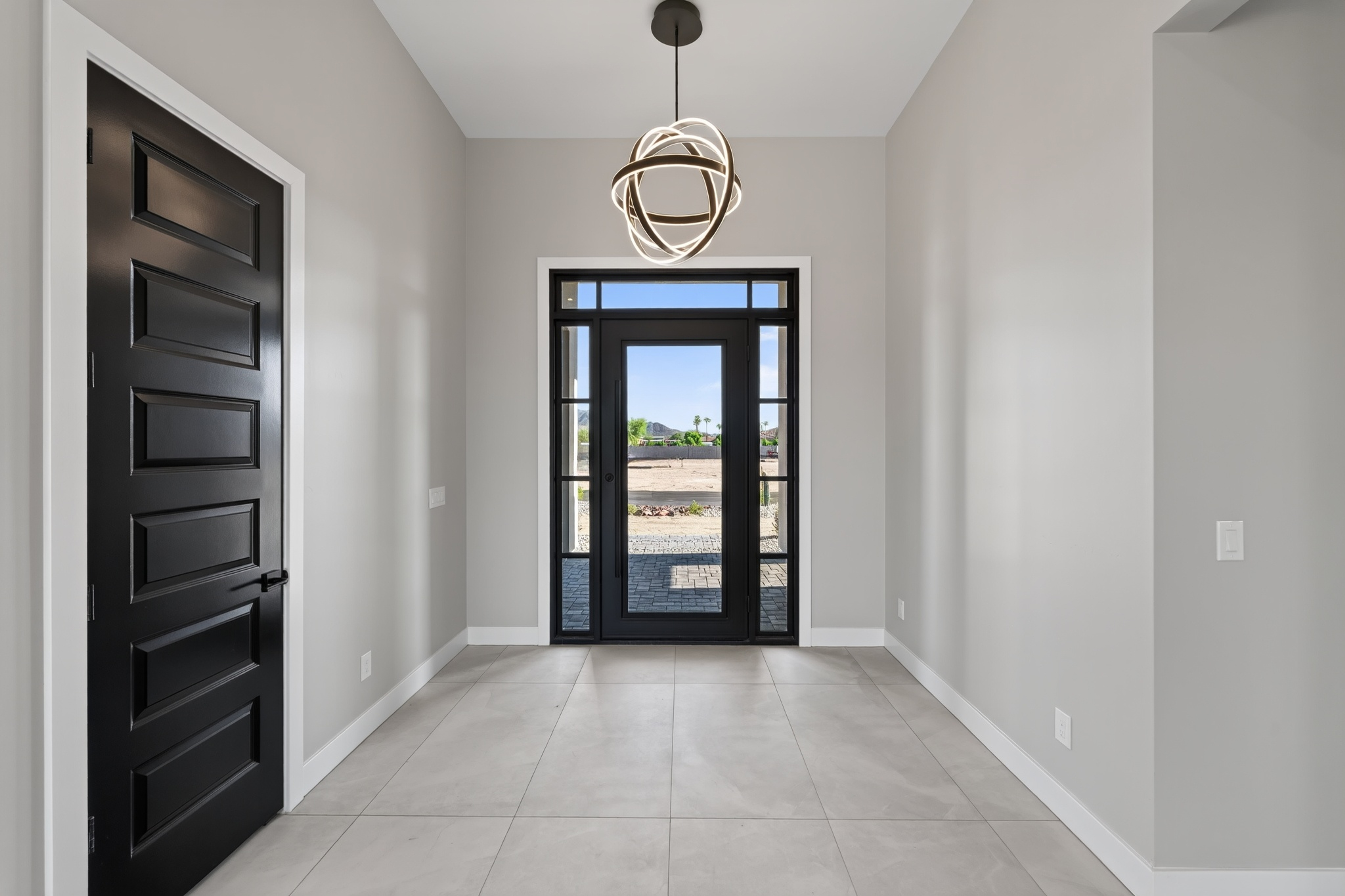 Modern Arizona home entryway with black doors and contemporary lighting