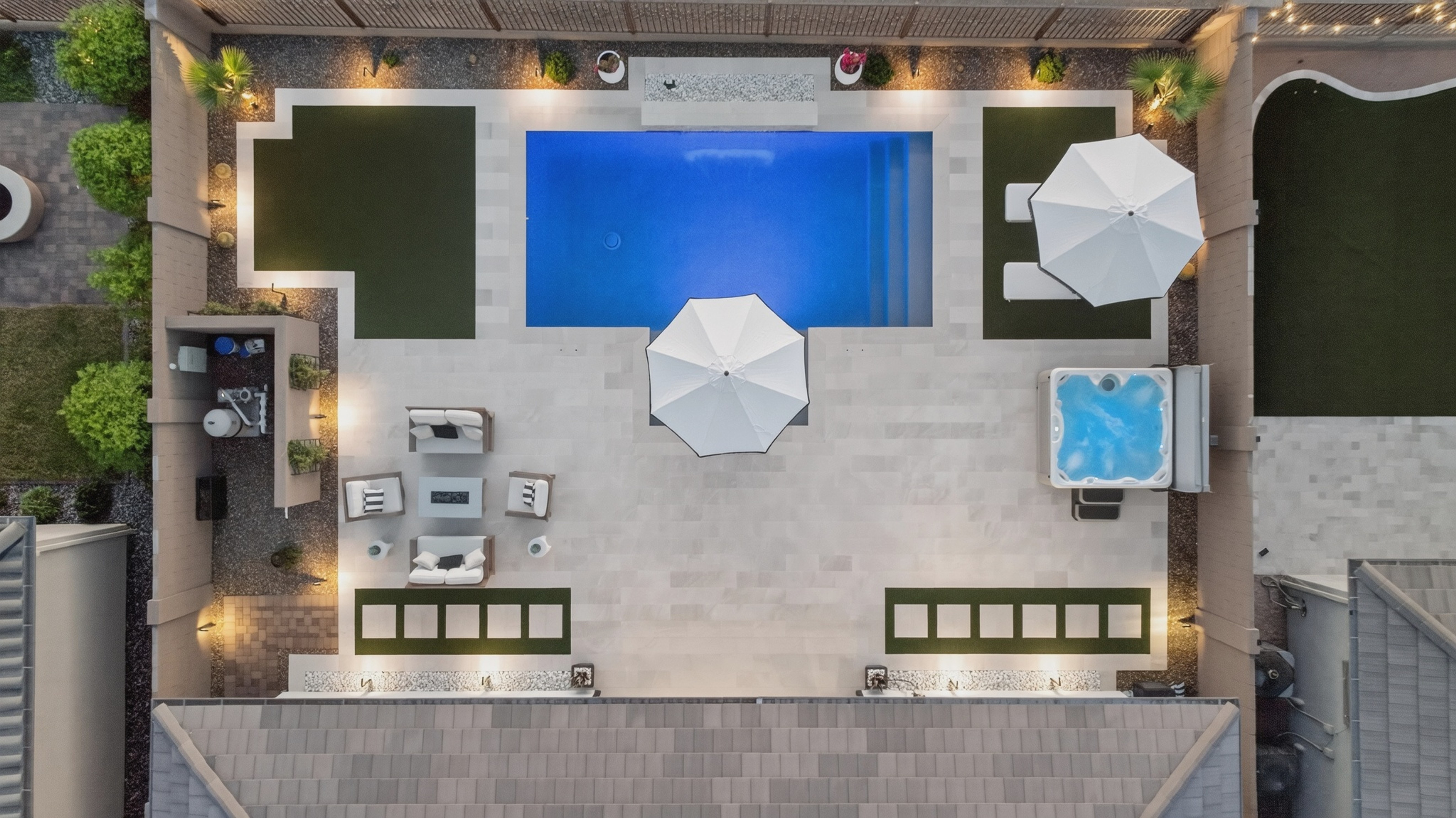 Straight-down aerial photograph of a backyard pool, spa, patio and umbrellas