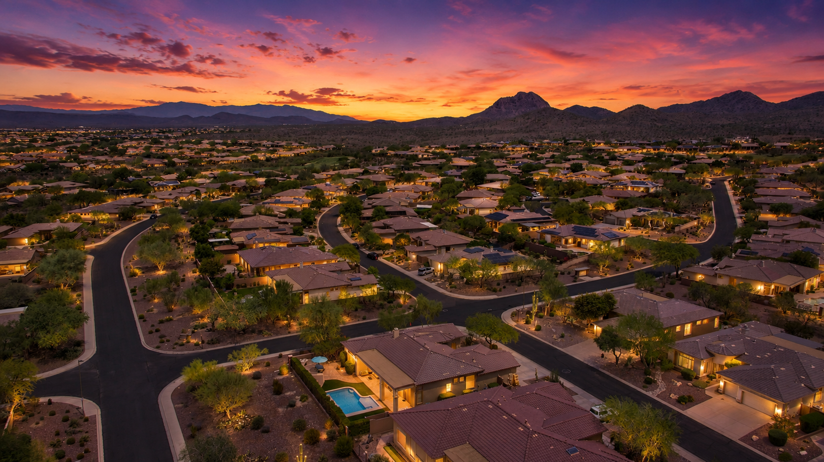 Aerial twilight view of an Arizona residential community with mountains on the horizon