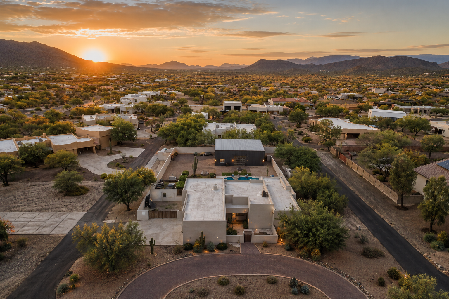 Aerial view of Desert Hills, Arizona, at sunset — large-lot custom homes set in open Sonoran Desert with distant mountain ranges and a golden North Valley sky